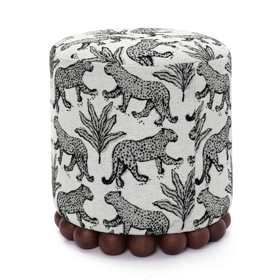 Gray animal-print ottoman with dark wood ball base; rounded cylinder silhouette.