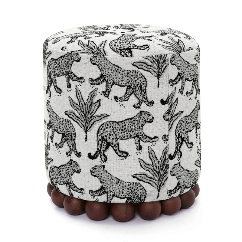 Gray animal-print ottoman with dark wood ball base; rounded cylinder silhouette.