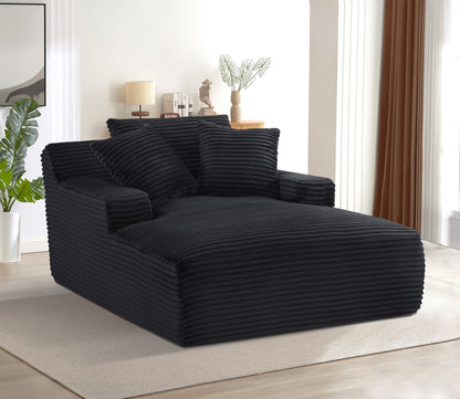 Black oversized chaise lounge sleeper with ribbed foam cushions and three throw pillows