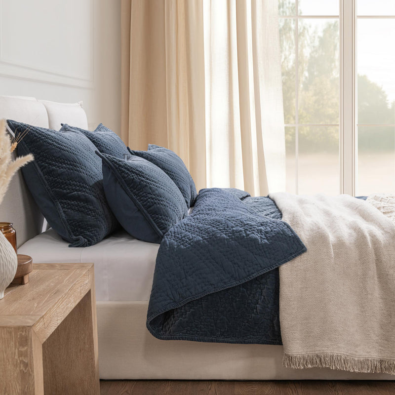 Dark blue velvet pillow sham with textured quilted fabric and fringed trim