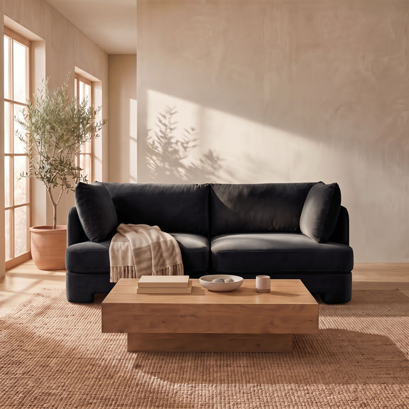Black velvet upholstered loveseat with rounded arms and two back cushions
