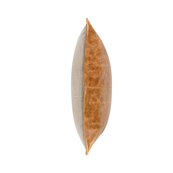 Tan leather lumbar pillow shown from the side with contrasting seam line
