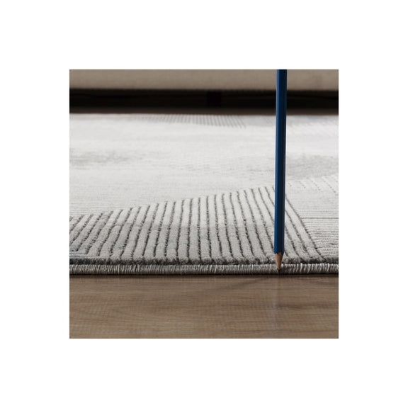 Gray geometric area rug edge with short pile texture, close-up