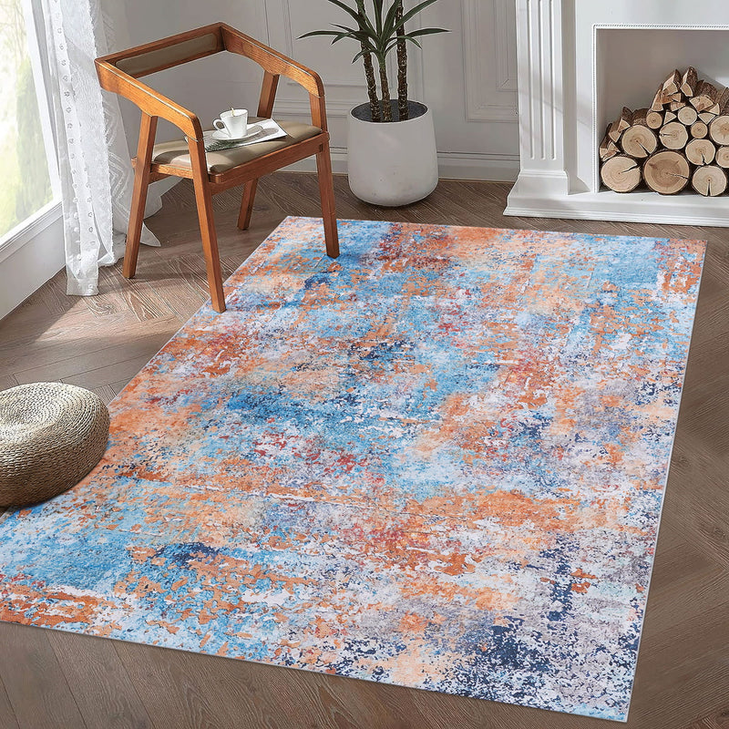 Rectangular washable area rug with blue and orange abstract speckled pattern