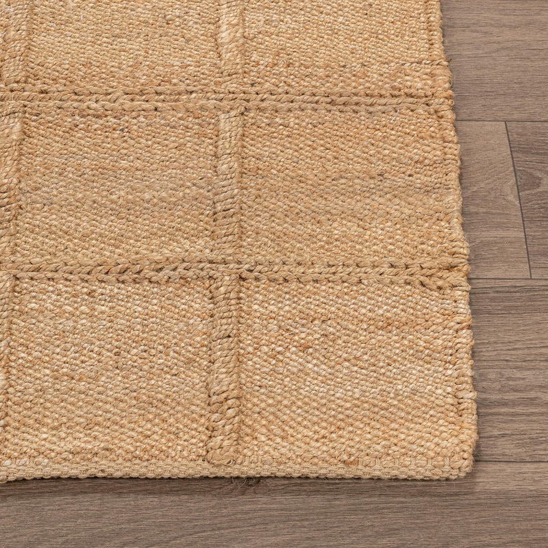 Tan jute area rug close-up with woven grid squares and stitched border edge
