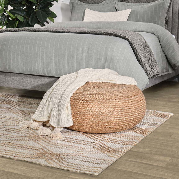 Beige diamond patterned area rug with short fringe, shown on a hardwood floor