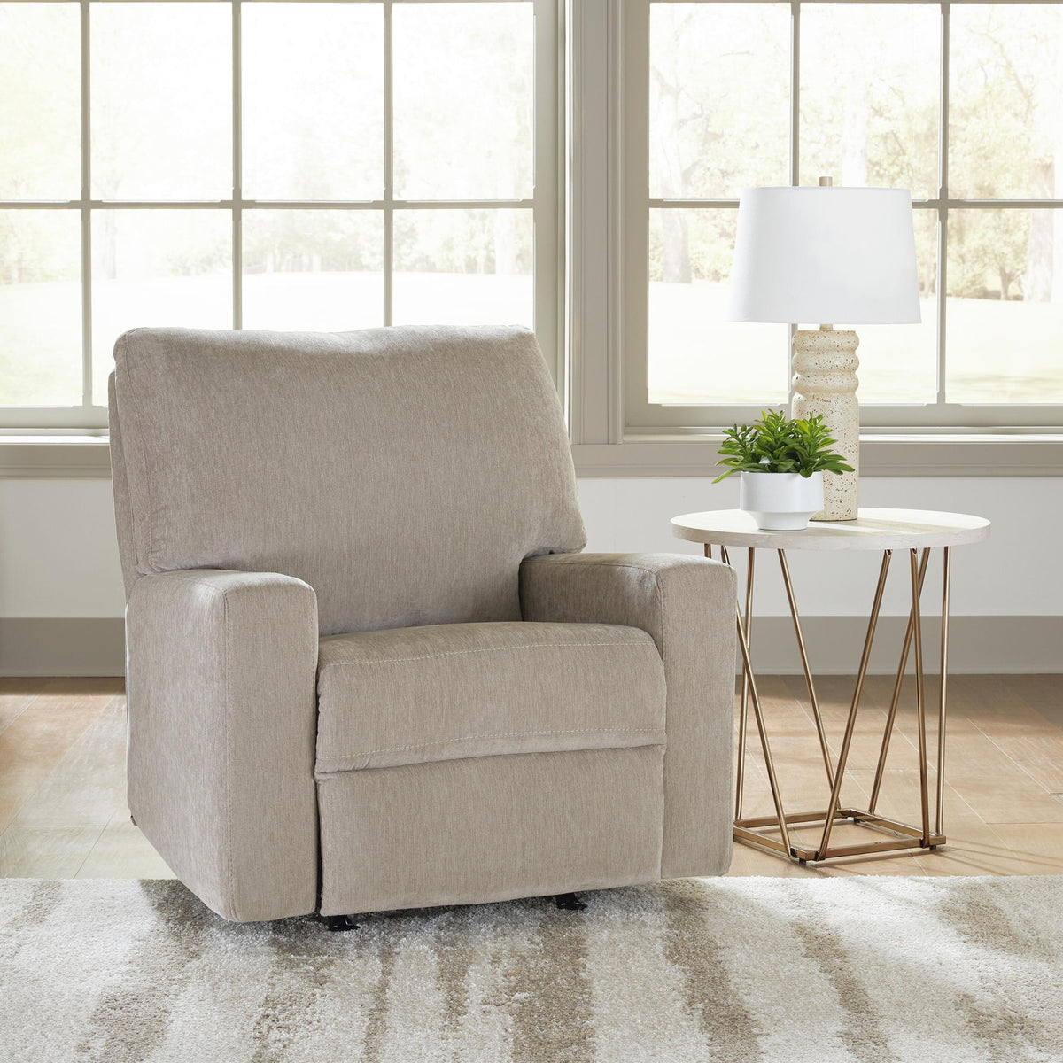 Gray fabric rocker recliner with padded arms, cushioned seat, and tall backrest.