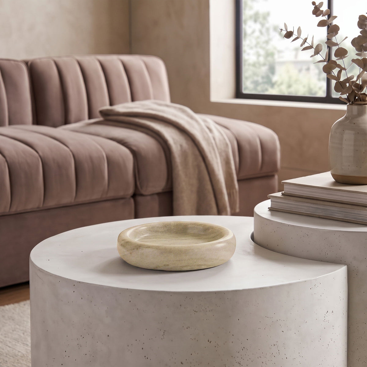 Cream white marble round tray on a table with subtle stone veining visible.