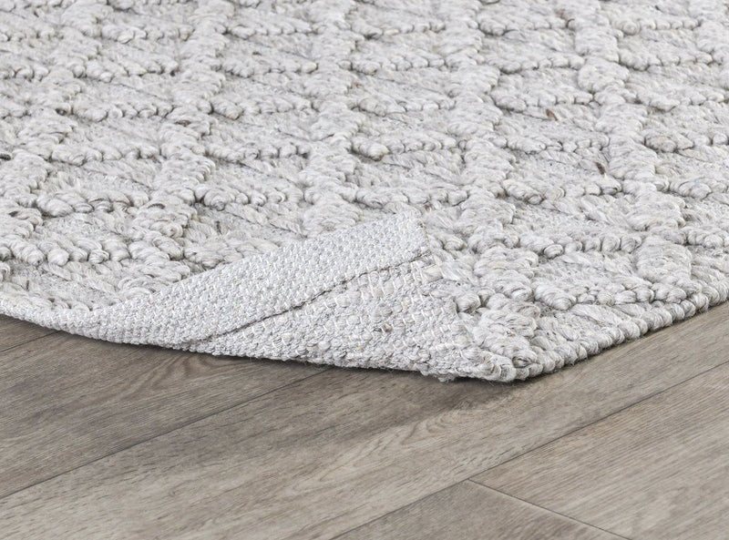 Ivory textured area rug with raised loop surface and low-profile woven edge.