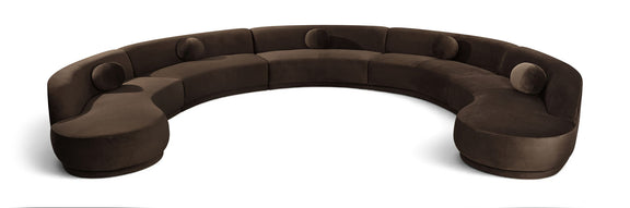 Dark brown velvet sectional sofa with rounded, button-tufted seat cushions.