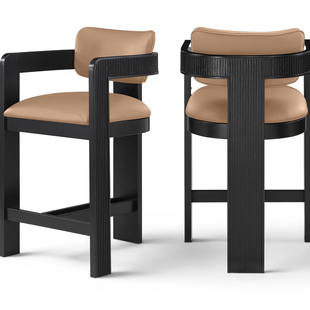 Two vegan leather counter stools with warm tan upholstered seats and black ribbed frames