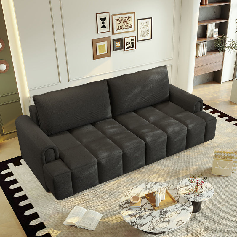 Black four-seat couch with two back cushions and segmented seats, shown in a living room.