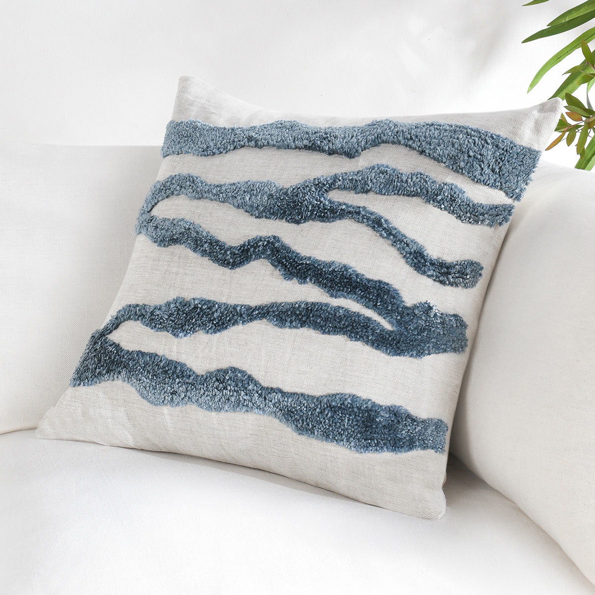 Decorative pillow with blue wavy stripes on light fabric
