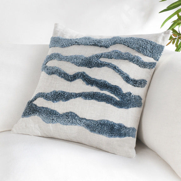 Decorative pillow with blue wavy stripes on light fabric