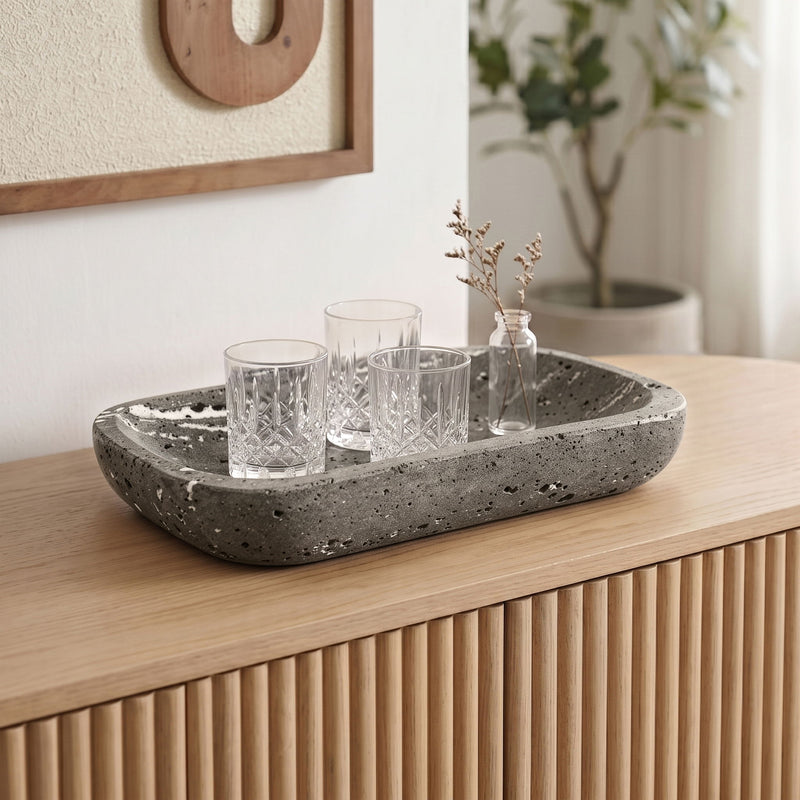 Gray travertine tray with four glass cups and small stems.