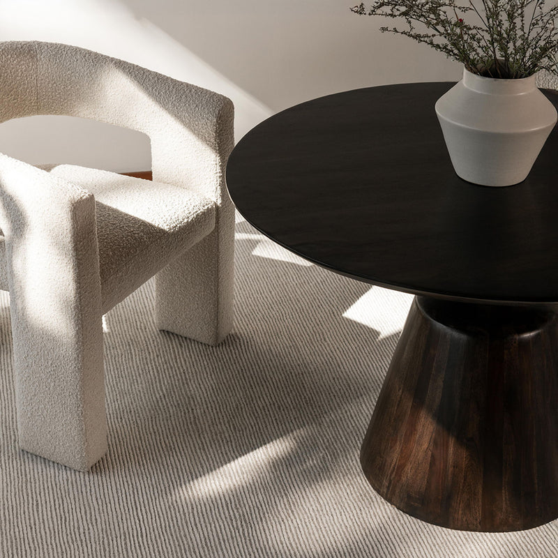 Round dark wood dining table with wide flared pedestal base