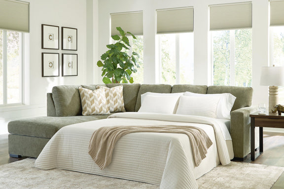 Green sleeper sectional sofa with corner chaise and white throw pillows