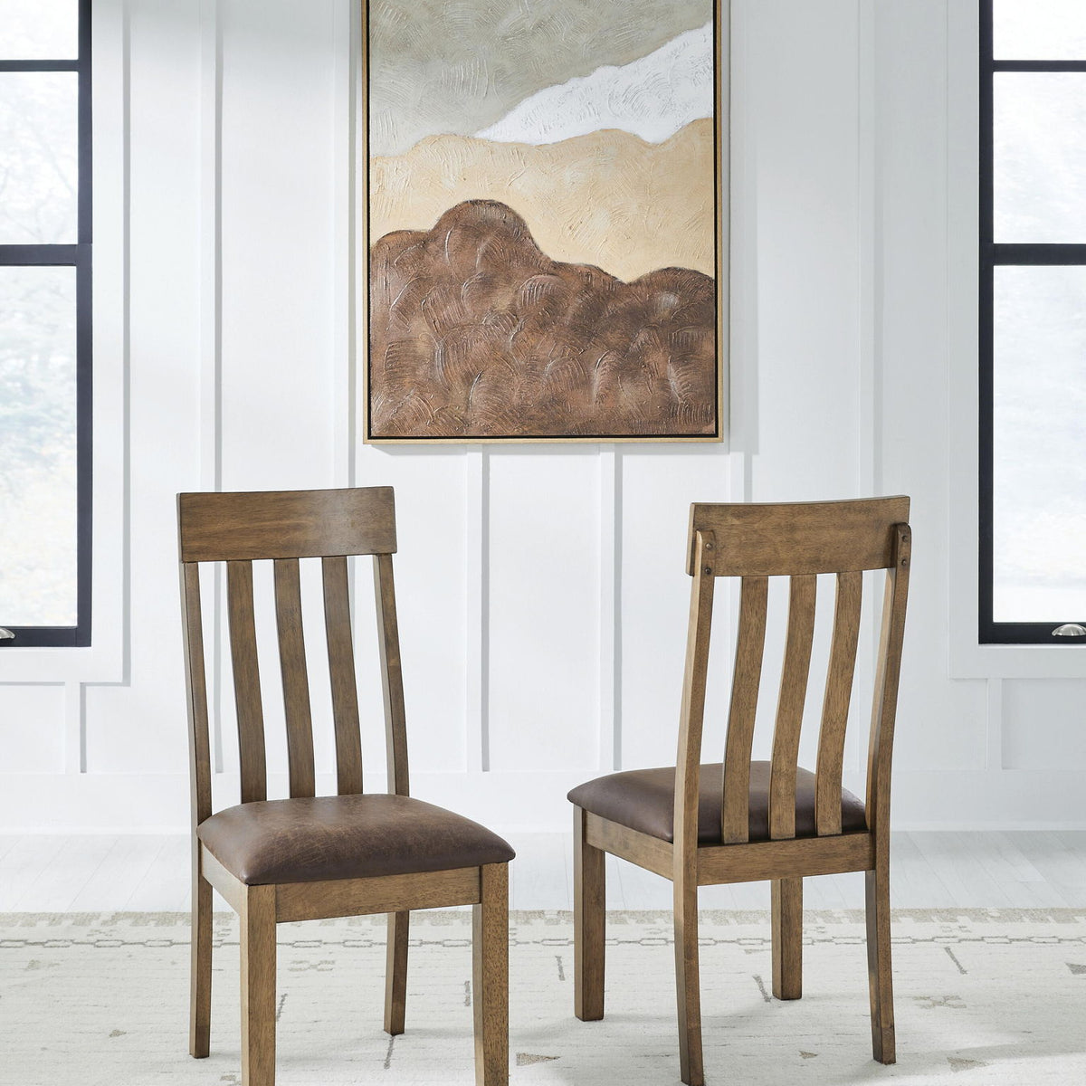 Two light brown dining side chairs with dark upholstered seats and slatted backs