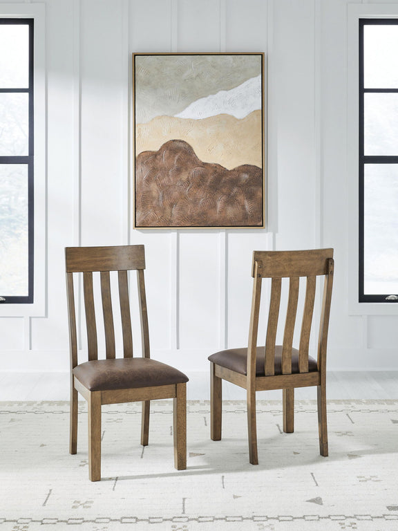 Two light brown dining side chairs with dark upholstered seats and slatted backs