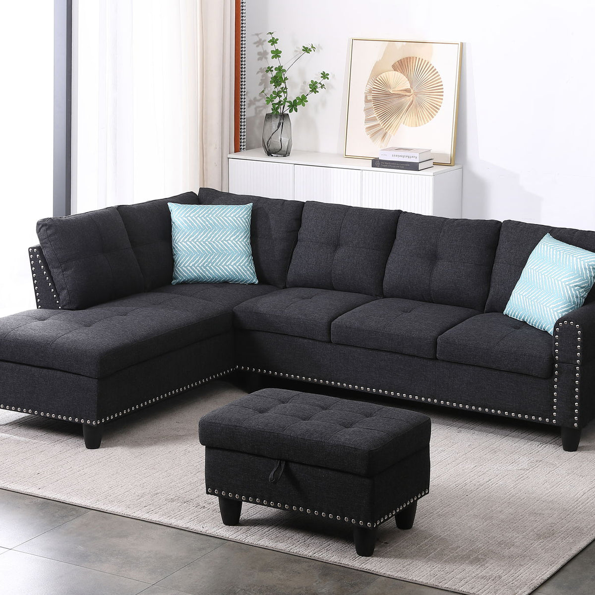 Dark gray sectional sofa with left-facing chaise and ottoman, two blue accent pillows