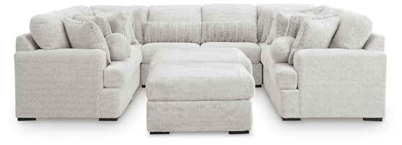 Light gray cuddle plush sectional sofa with central ottoman and rounded arm seat blocks