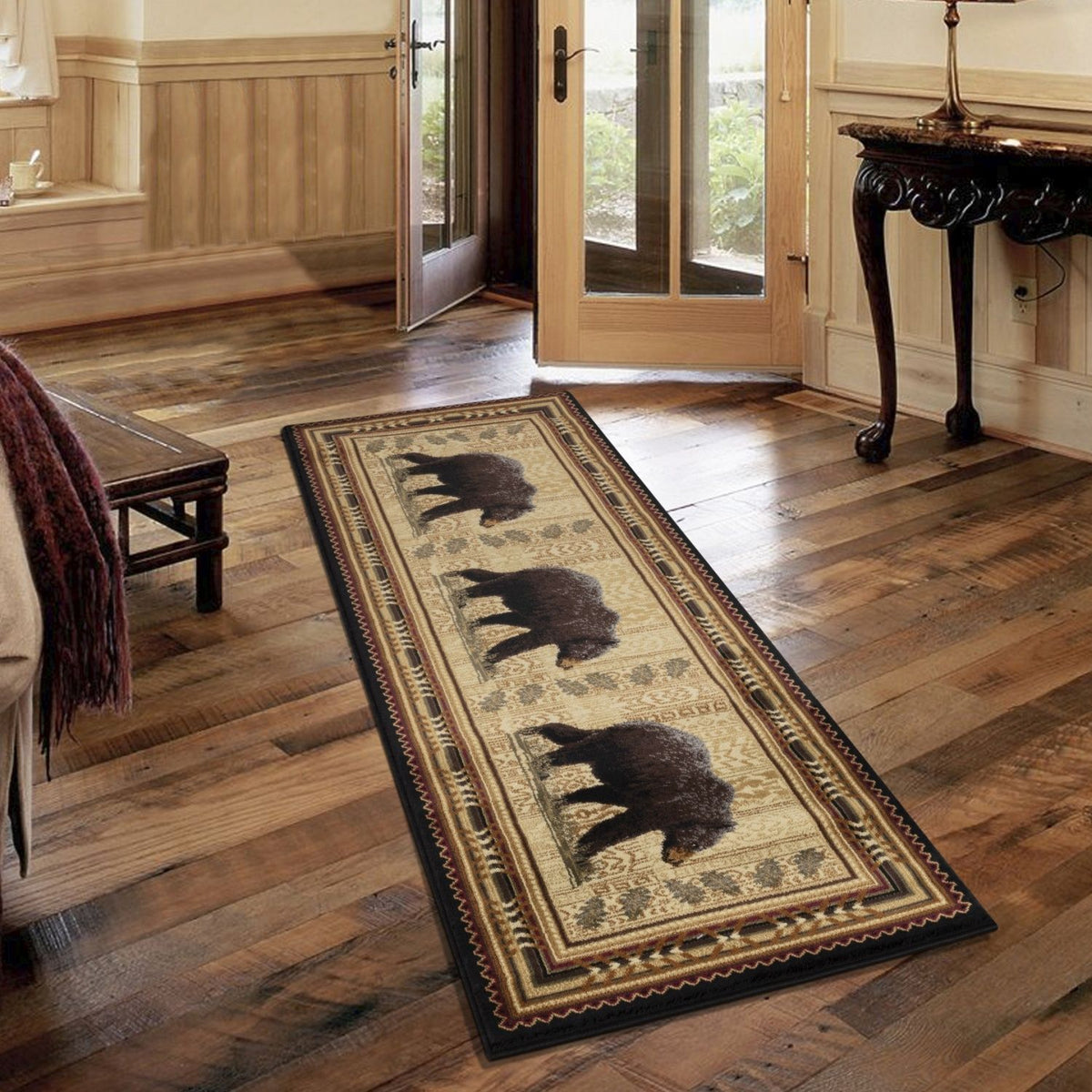 Rectangular lodge area rug in cream and dark tones with black bear motif and patterned edge