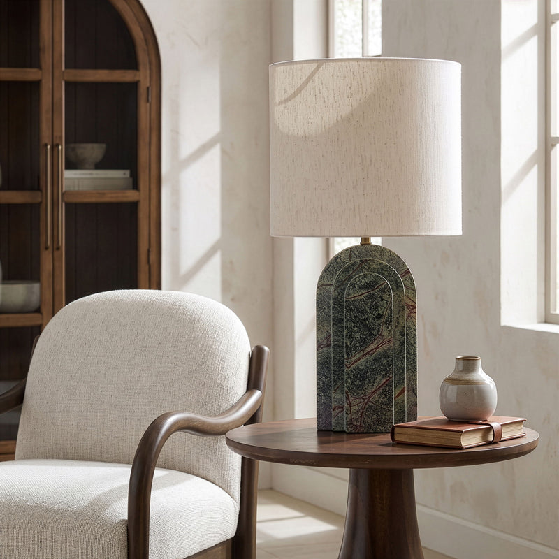 Table lamp with beige fabric shade and dark green textured arched stone base