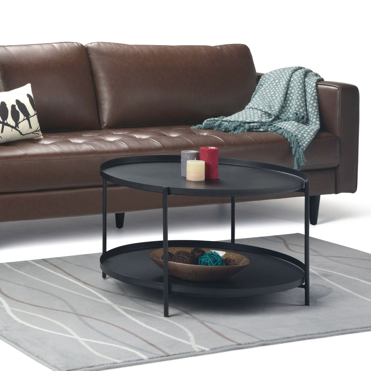 Black round two-tier metal coffee table in front of sofa seating
