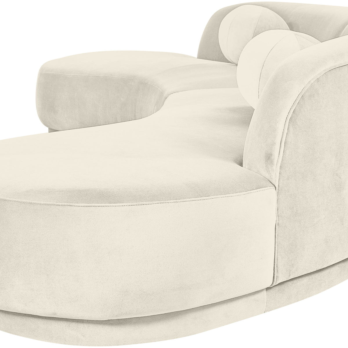 Light beige velvet sectional sofa with rounded arms and cushioned chaise