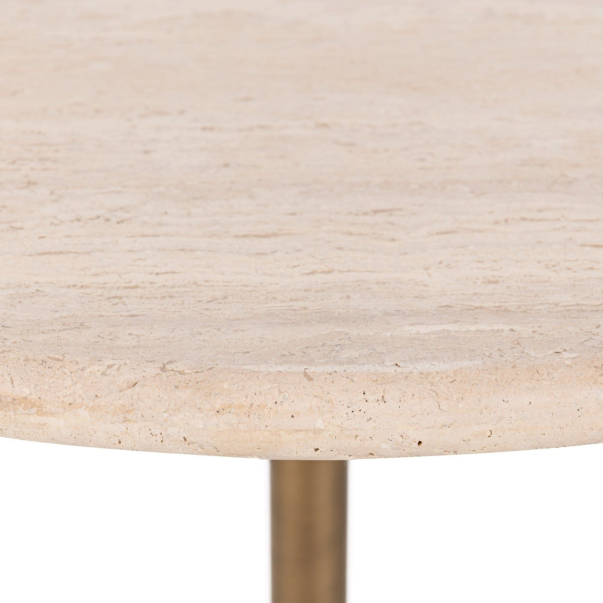 Close-up of light beige travertine tabletop surface with speckles and veining.