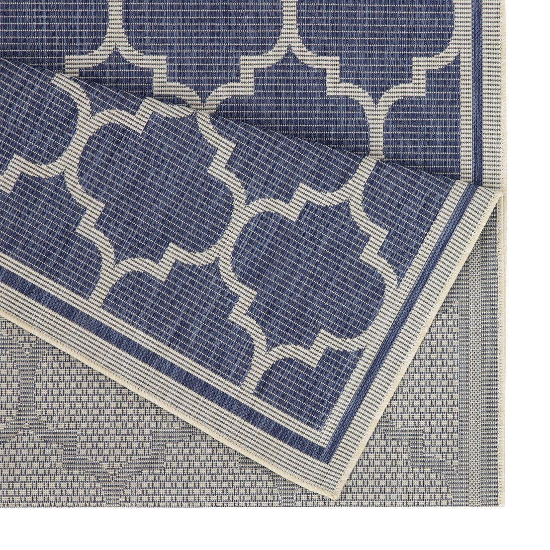 Blue polypropylene area rug close-up showing quatrefoil pattern and border