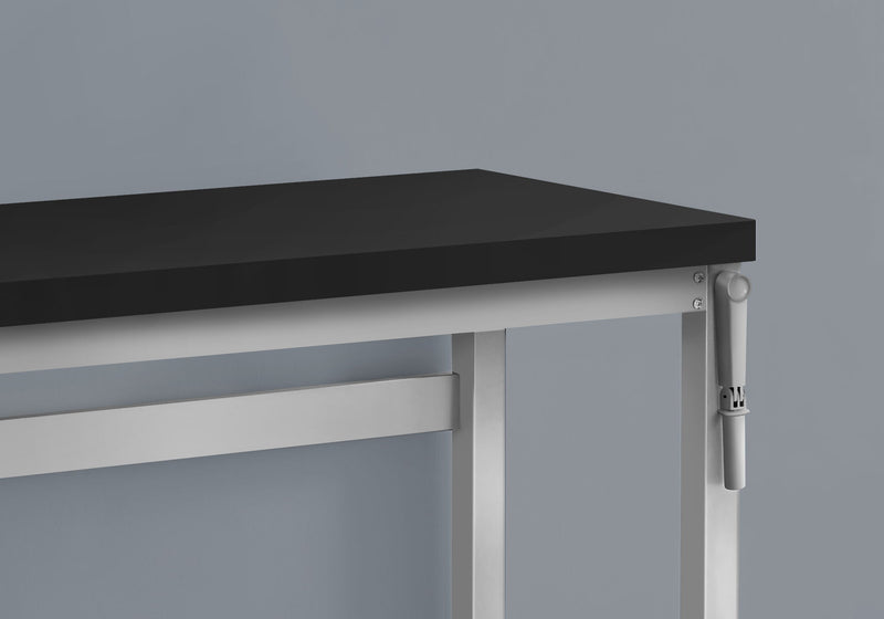 Close-up of height adjustment hardware on light-colored standing desk frame
