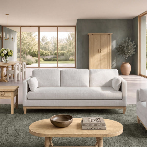 Beige fabric sofa with three back cushions and loose seat pillows, on wooden legs