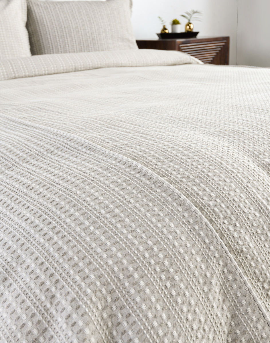 Closeup of white textured woven pillow sham with vertical stripe stitching