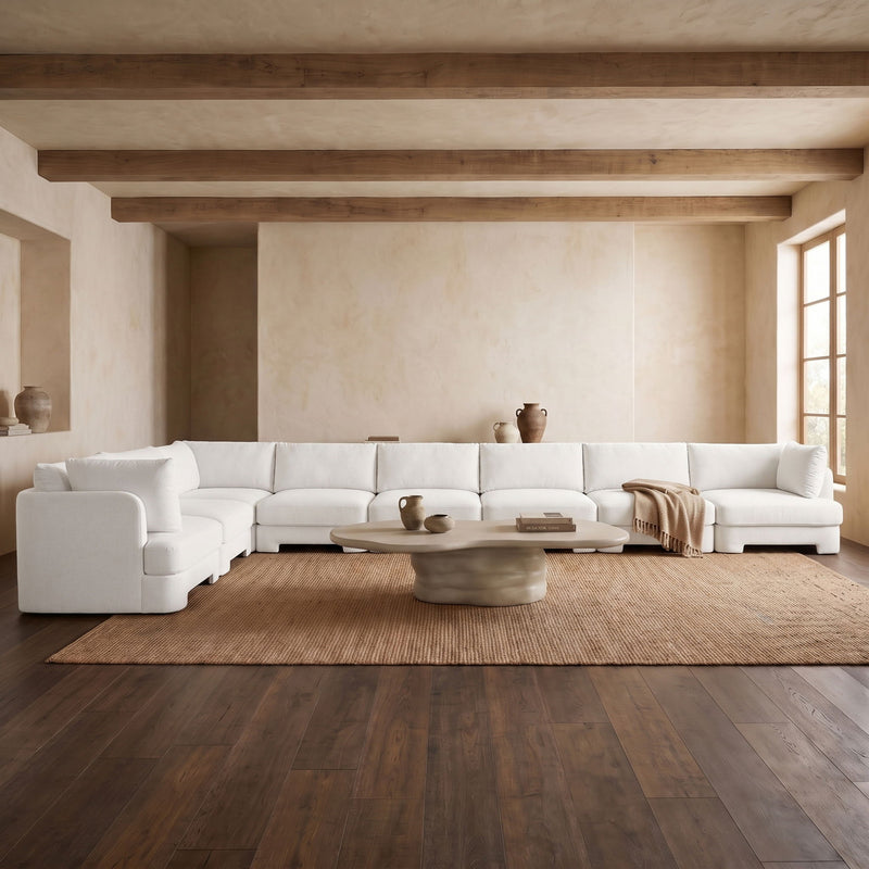 White L-shaped velvet sectional sofa set in a living room layout with matching cushions