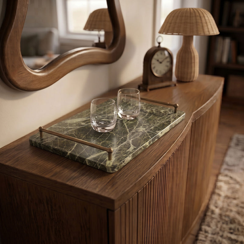 Dark green marble serving tray with brass corner handles on a wooden surface.