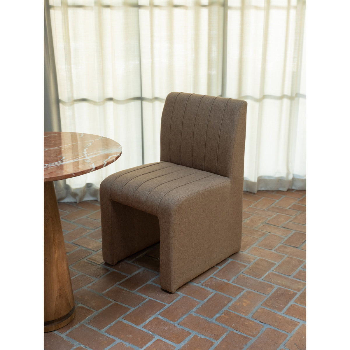 Light brown dining chair with tall channel back and padded armrests, square base