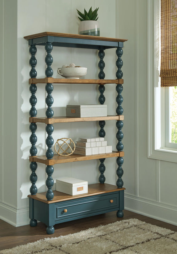 Wood and teal bookcase with open shelves and lower drawer, styled with decor on top