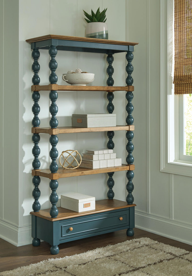 Wood and teal bookcase with open shelves and lower drawer, styled with decor on top