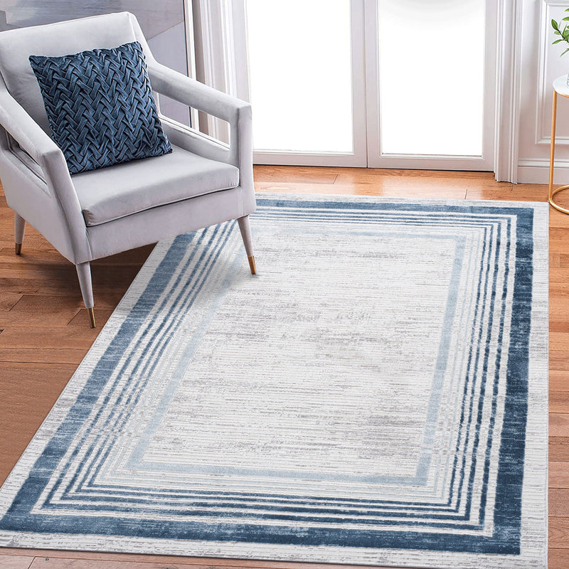 Blue and white bordered area rug with layered rectangular frame design.