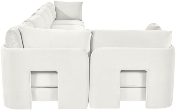 White velvet L-shaped sectional sofa with square armrests and tufted back cushions.