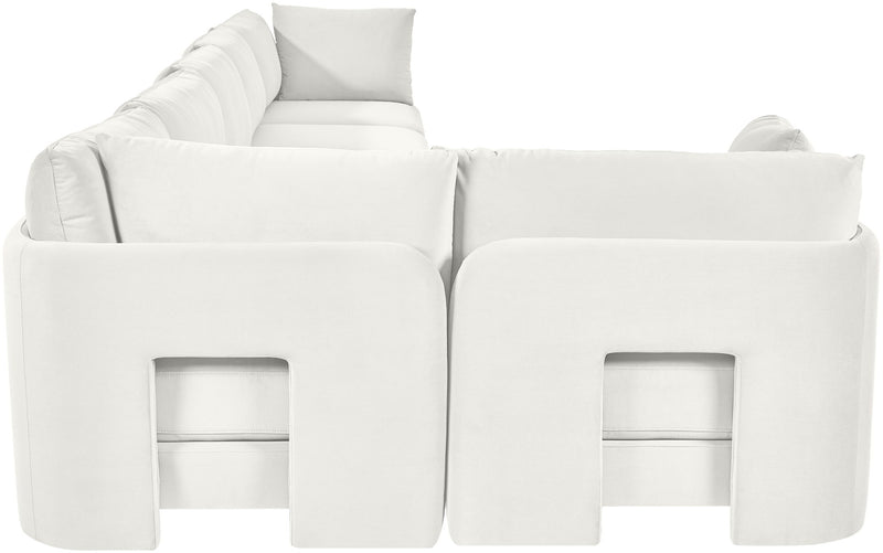 White velvet L-shaped sectional sofa with square armrests and tufted back cushions.