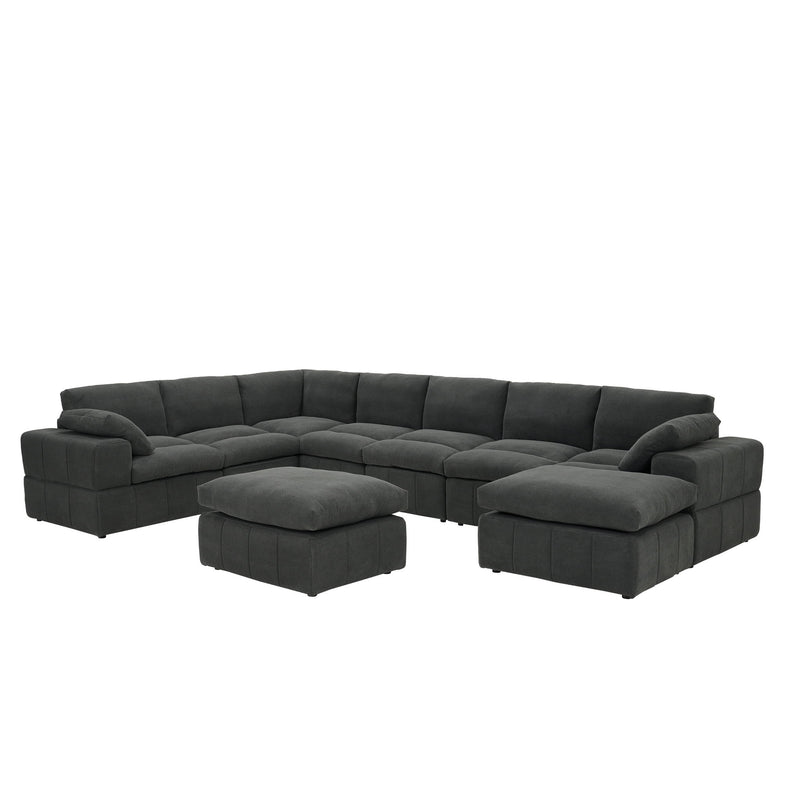 Dark gray L-shaped sectional sofa with broad arms, two ottomans and toss pillows