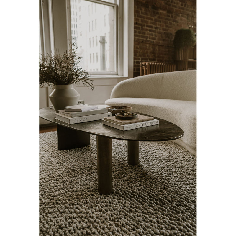 Dark brown oval coffee table with two pedestal legs and sculpted apron