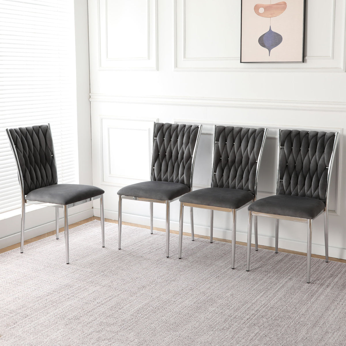 Set of four dark gray tufted dining chairs with chrome legs and padded seats