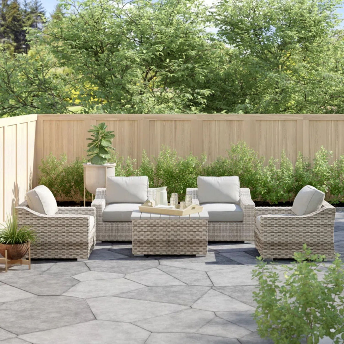 Gray wicker sectional seating group with light gray cushions and matching center ottoman