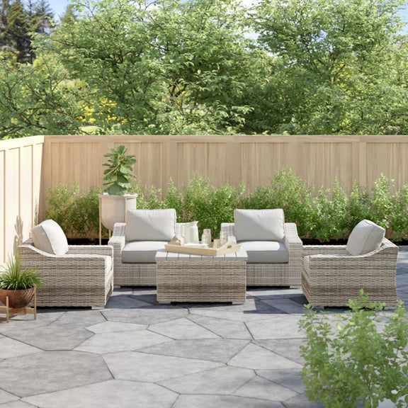 Gray wicker sectional seating group with light gray cushions and matching center ottoman