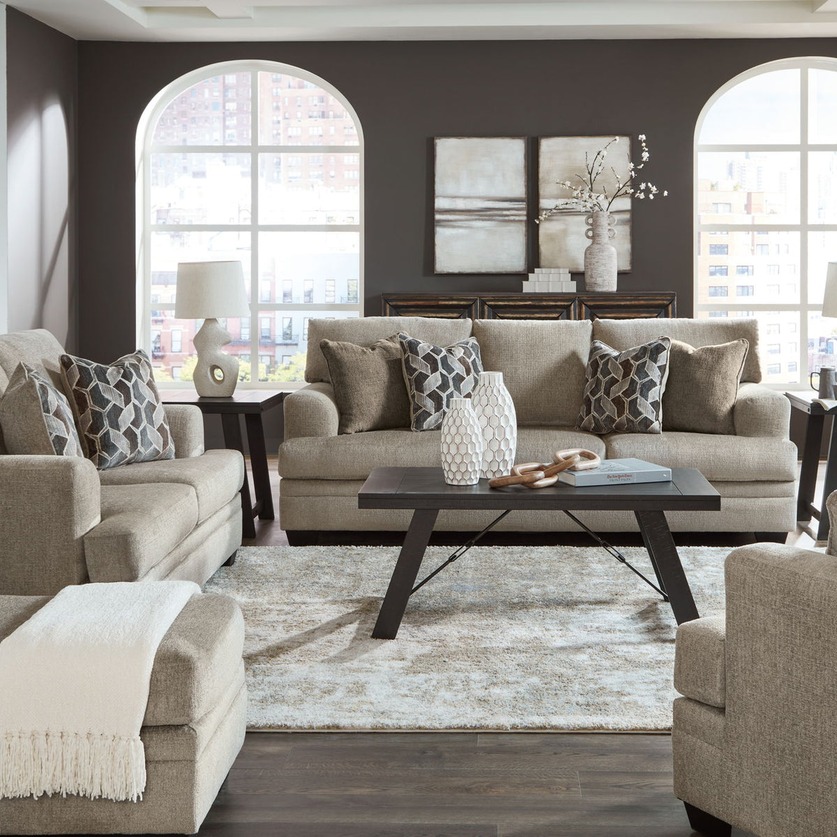 Living room sofa set with chaise-style section, accent pillows, and a center coffee table