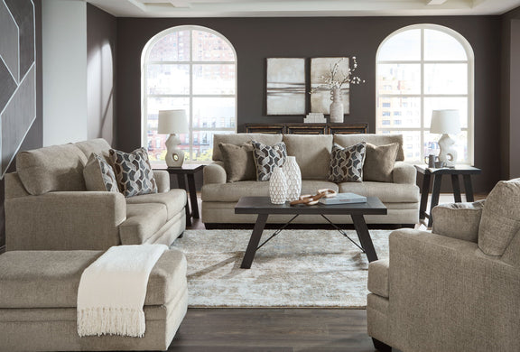 Living room sofa set with chaise-style section, accent pillows, and a center coffee table