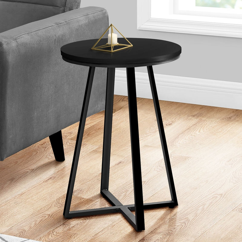 Black round accent side table with flat circular top and black tapered four-leg base